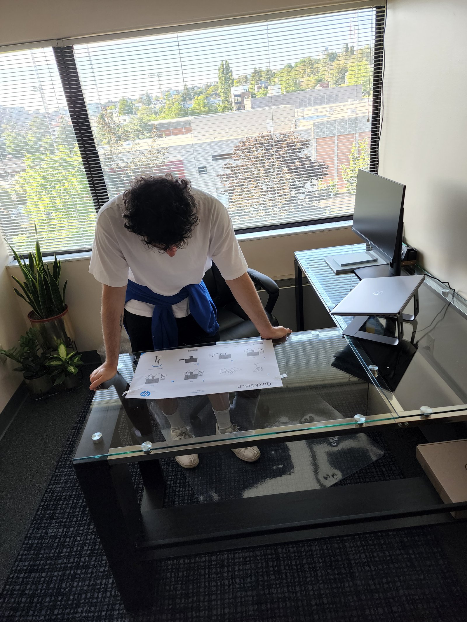 A young person working at a standing desk by a window