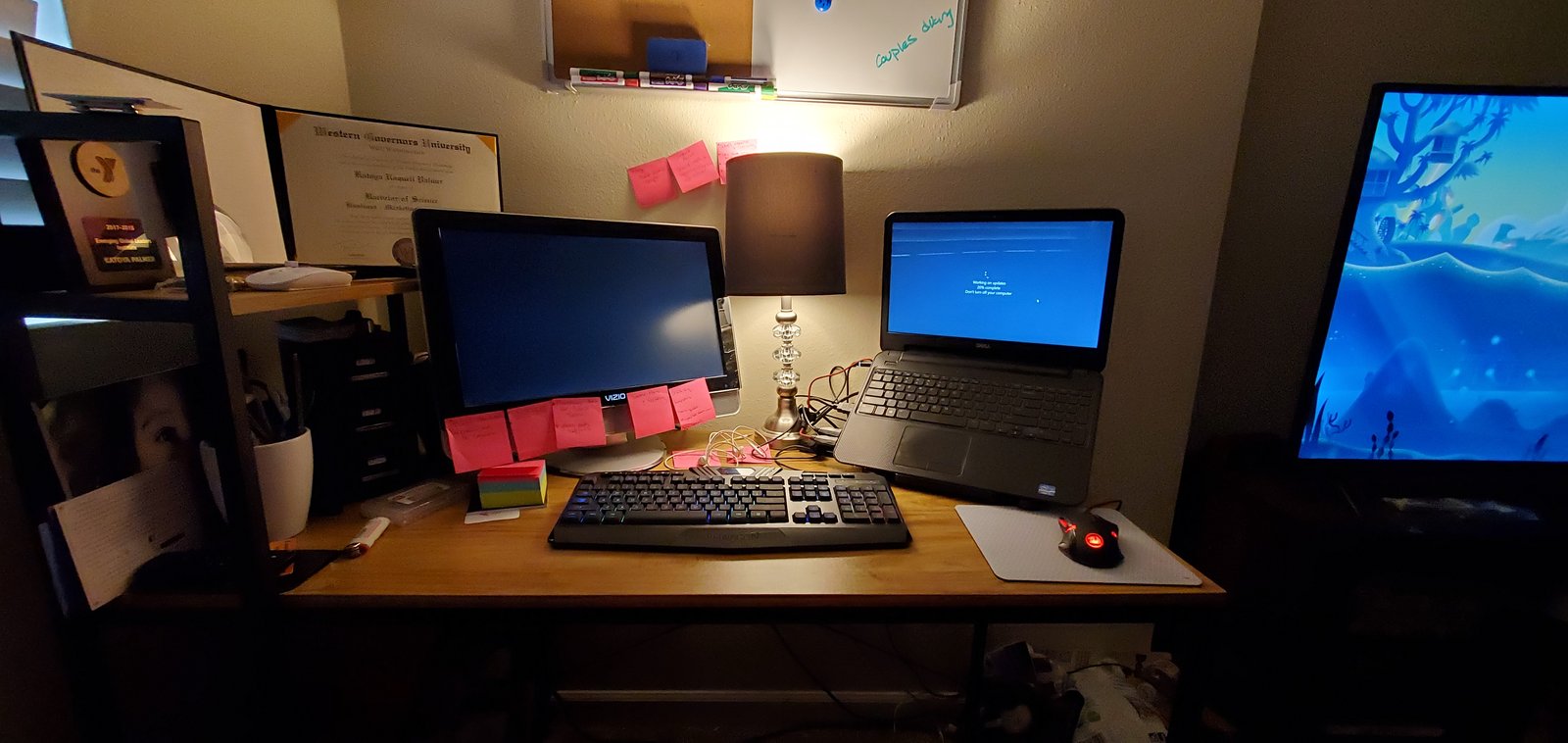 A home office desk with several monitors and a laptop