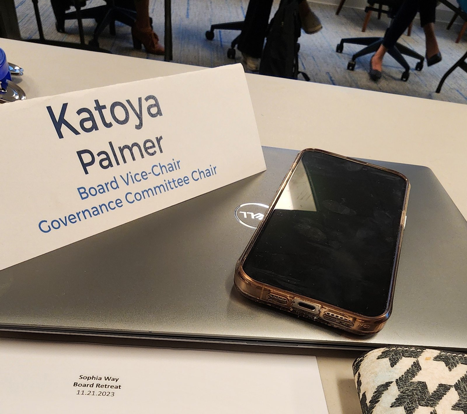 A name tent reading Katoya Palmer, Board Vice Chair, next to a phone on a laptop