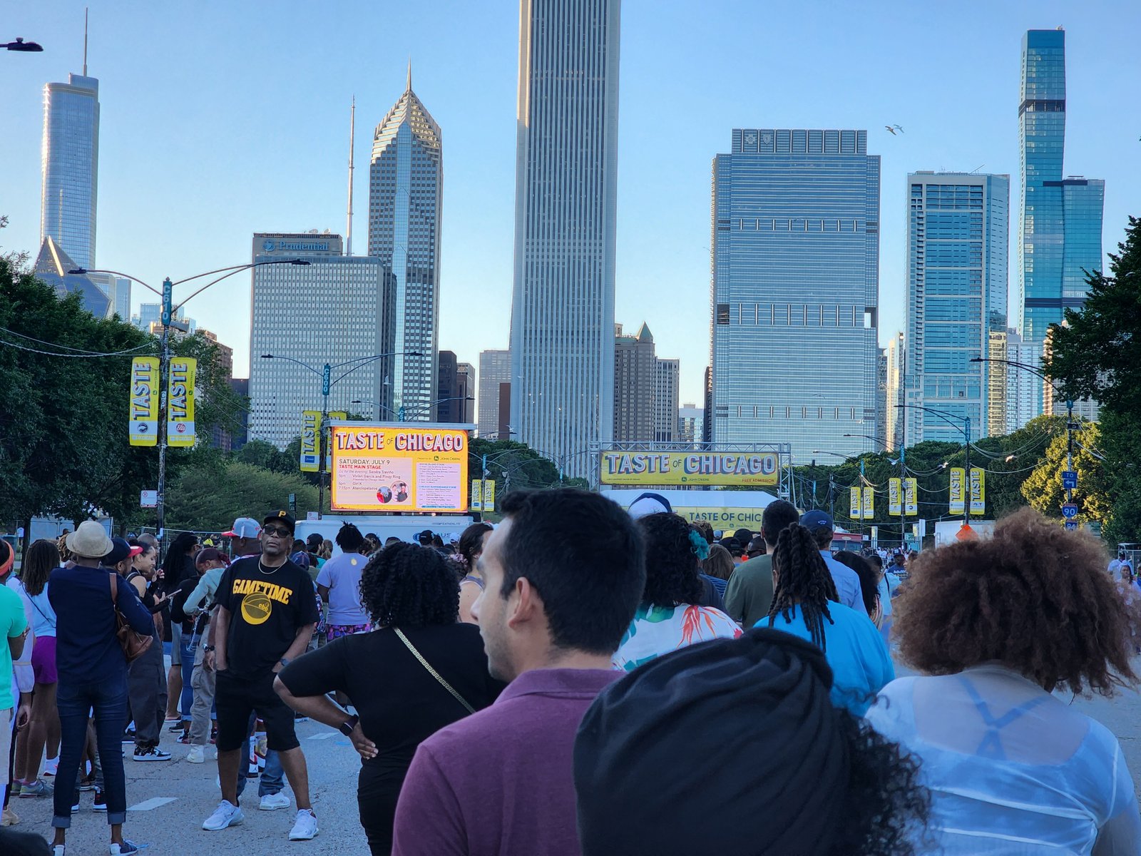 A crowd gathered in a city park with the Chicago skyline behind