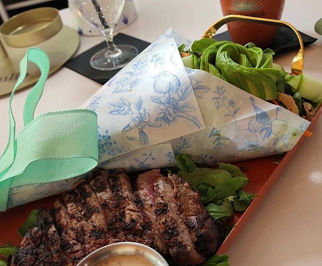 House salad with steak, wrapped in floral paper and ribbon like a bouquet