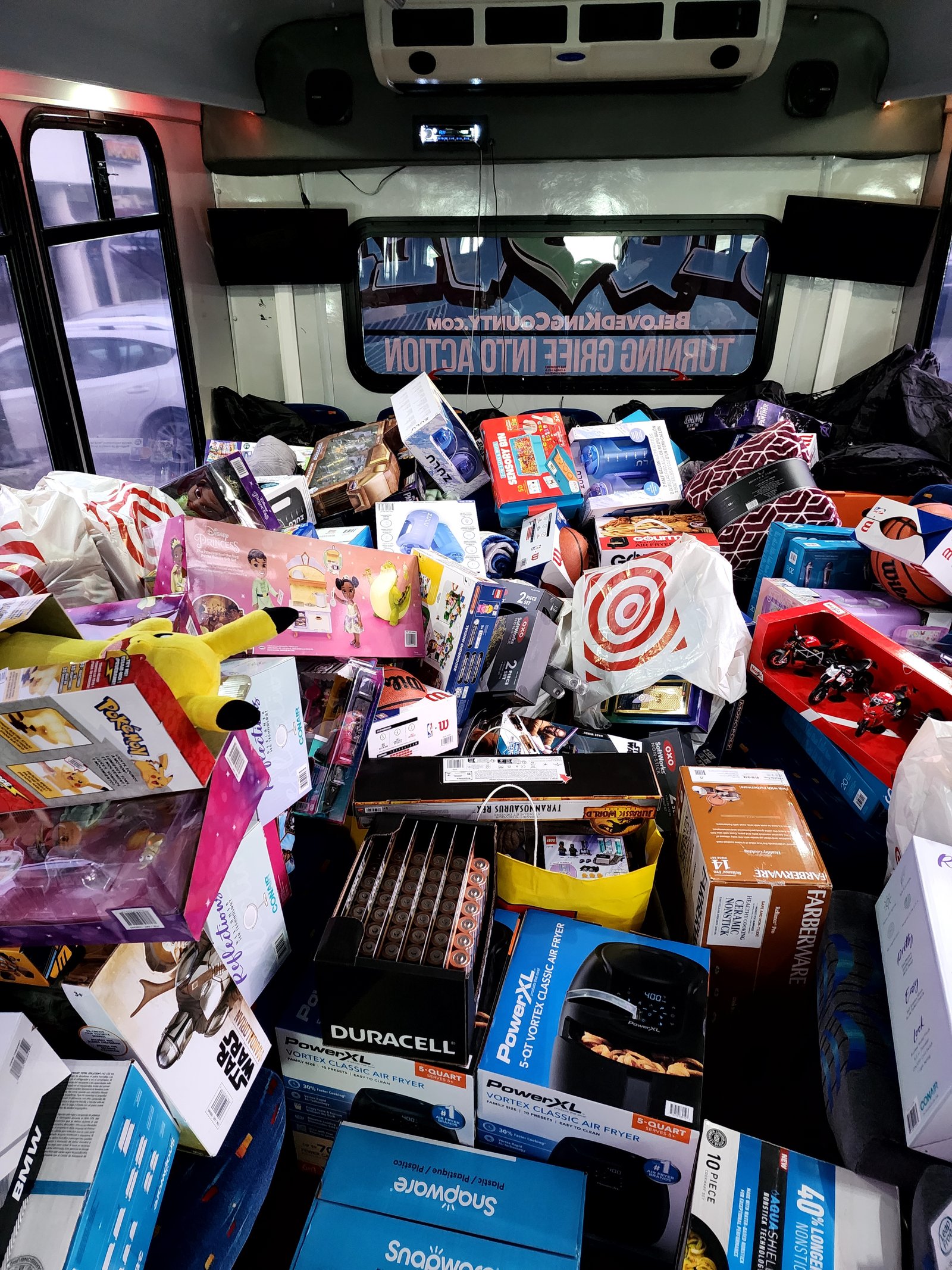 A van filled with toys and boxed gifts for a holiday giveaway